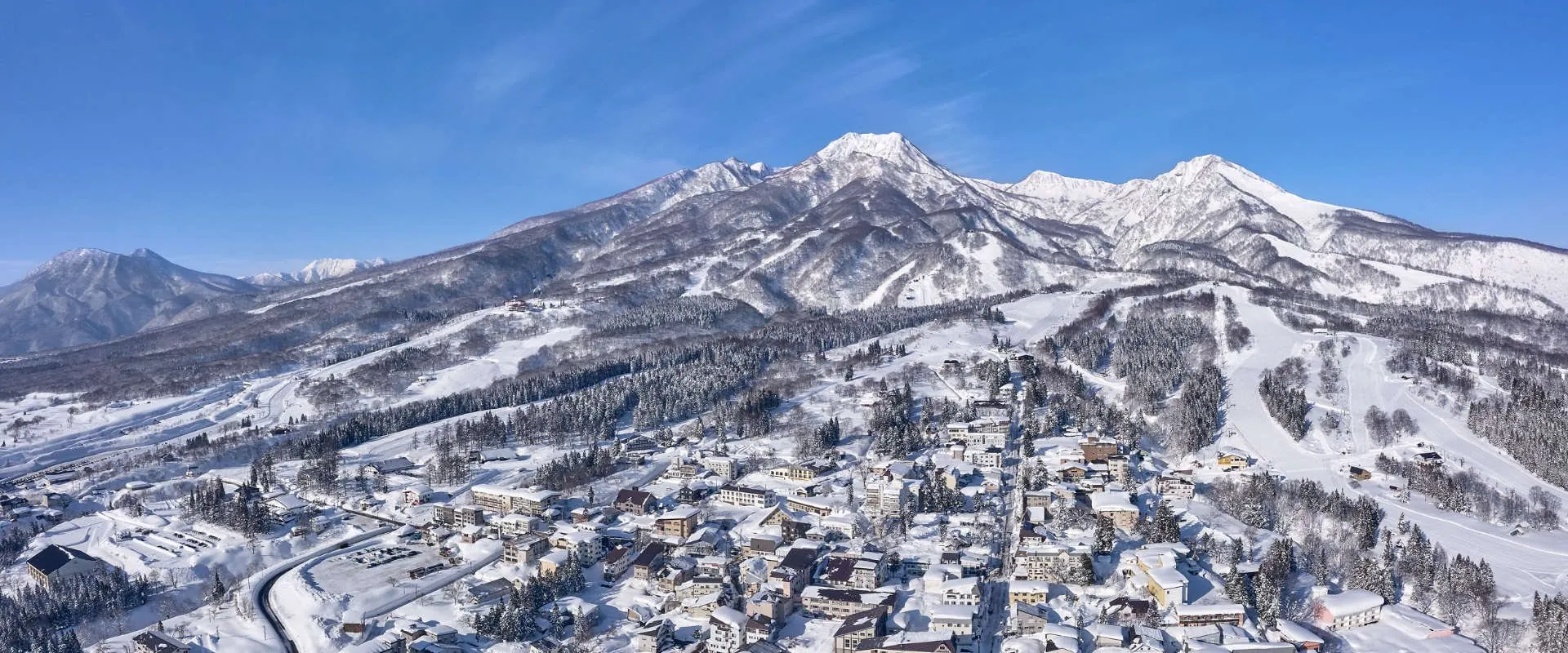 雪の妙高山と、ふもとの赤倉の町並み